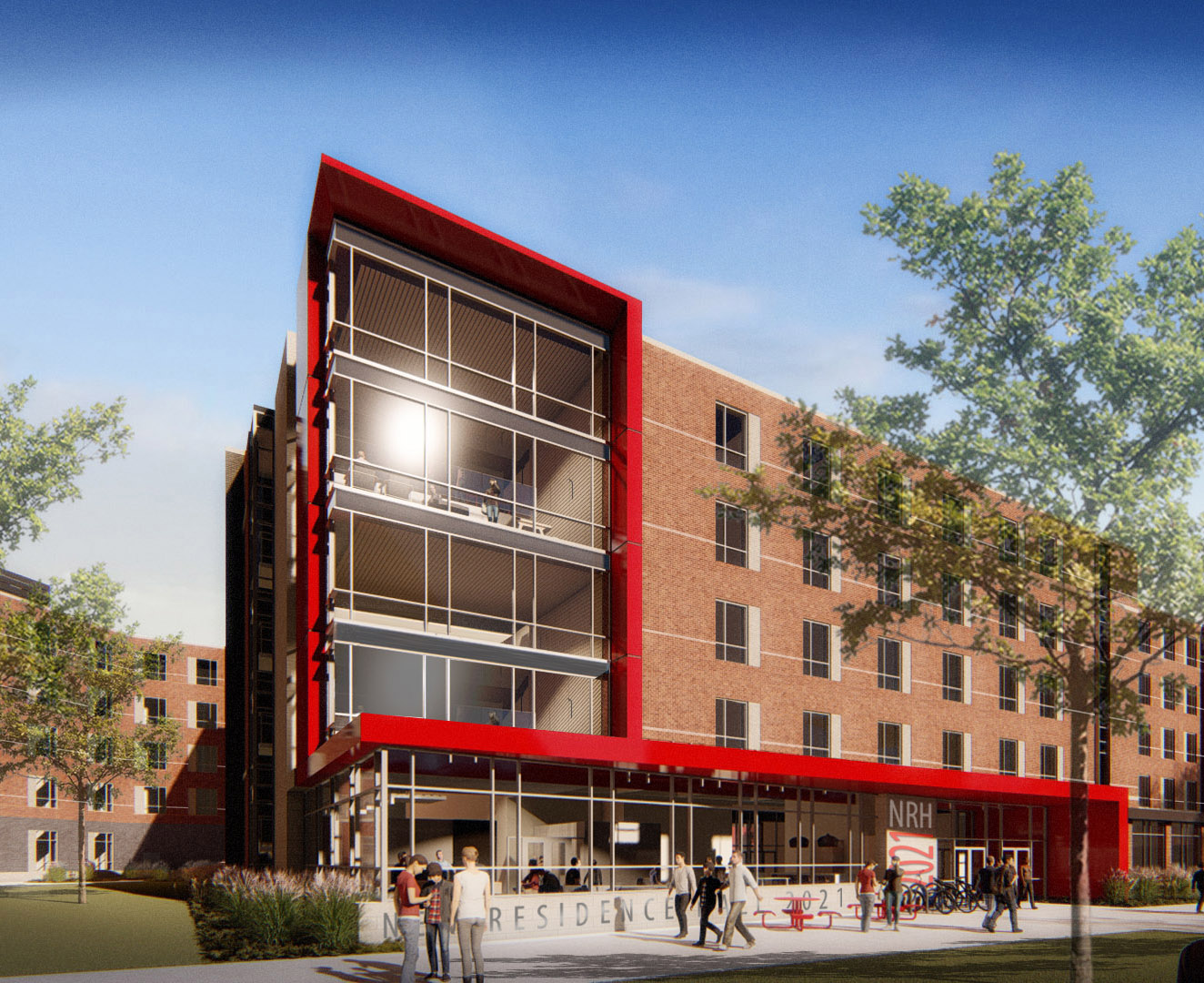 exterior of new residence hall one. brick with glass windows, four stories, and red trim