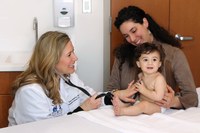 Forskningspraktiker som arbetar med en bebis och hans vårdgivare.