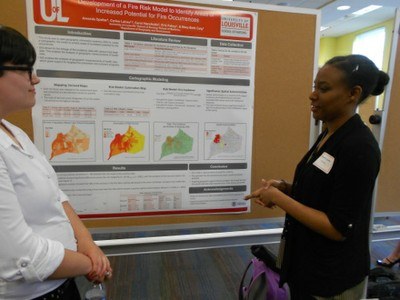 students discussing a research poster