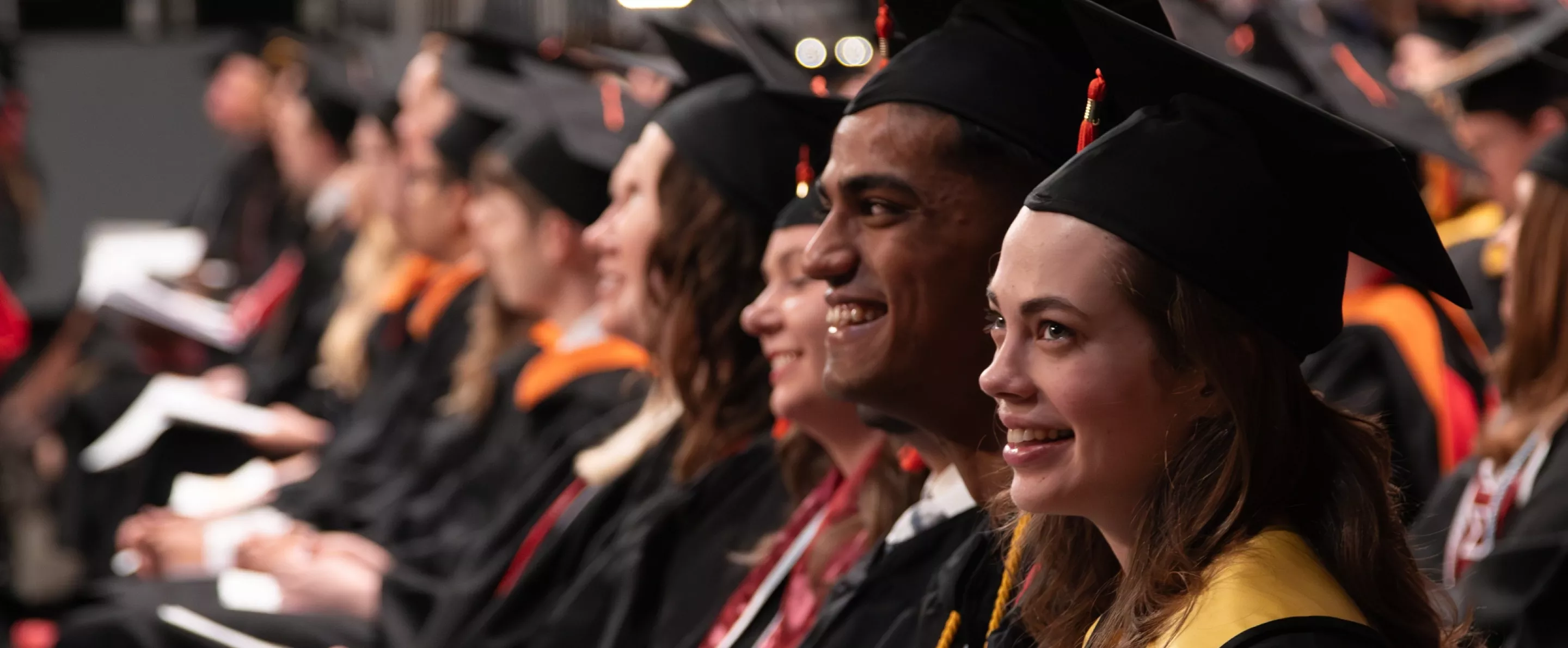 Engineering students smiling from their seats at Commencement.