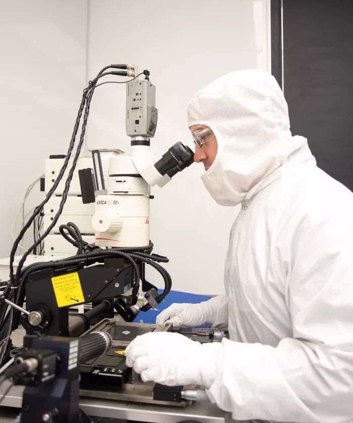 Micro Nanotechnology Center staff member looking into a microscope in the Clean Room.