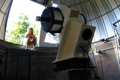 Physics and Astronomy Student sitting near the Moore Observatory telescope