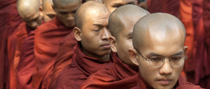 Monks in redish-orange robes in line