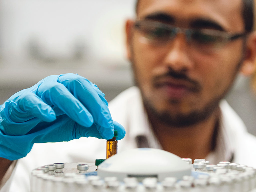 Close up of biology student using lab equipment