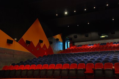 Photo of empty auditorium with red and black chairs