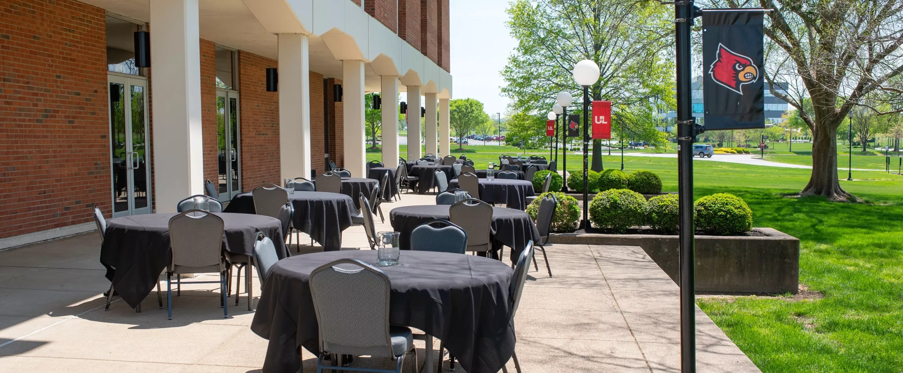 Outdoor patio seating area with sets of round tables outside Founders Union