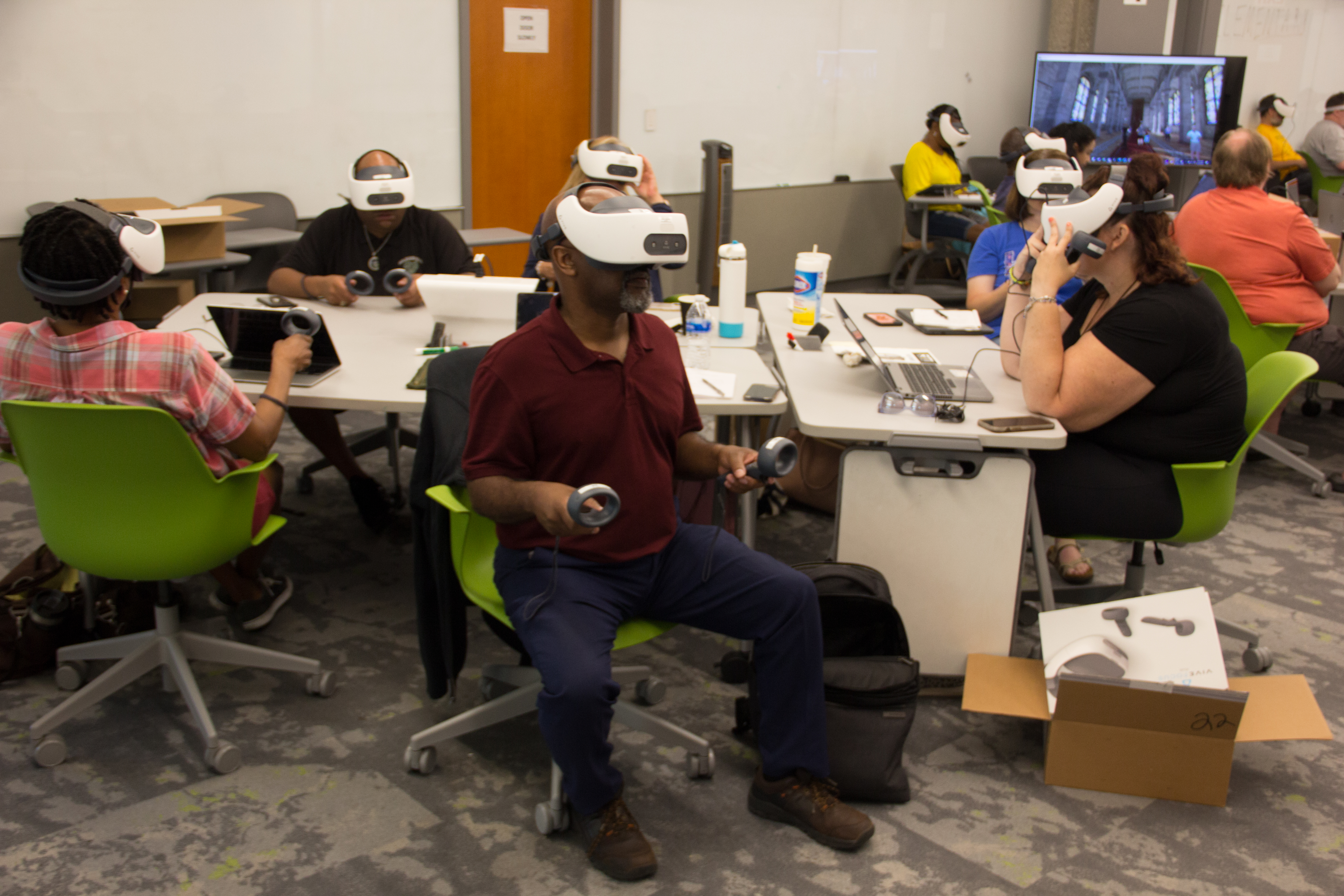 TILL staff members examining the newly acquired VR headsets.