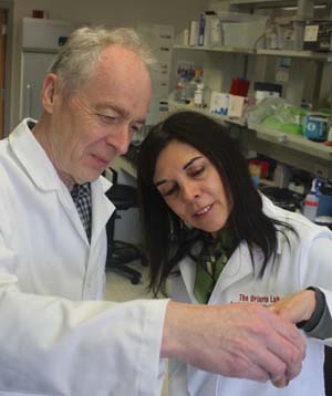 Richard Lamont and Silvia Uriarte examine bacterial culture sample in laboratory