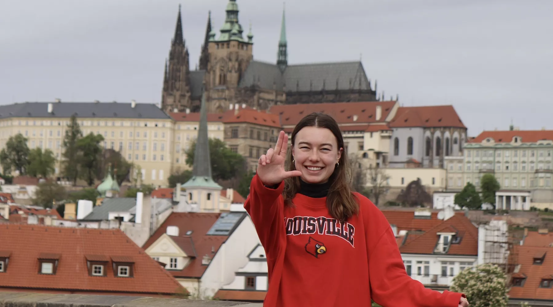 UofL student in front of Prague Castle with her L's up, UofL student in front of Prague Castle with her L's up
