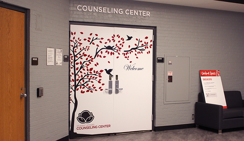 Doors to the Counseling Center decorated with tree branches and birds.