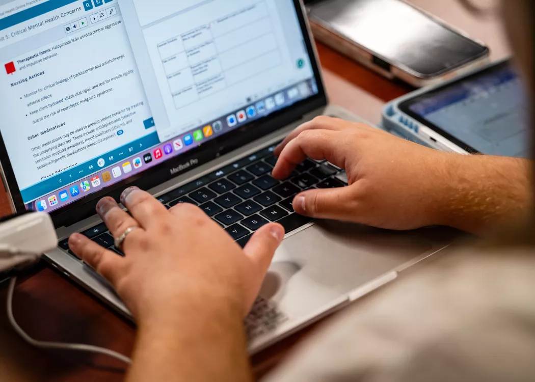Students in a nursing lecture listening and taking notes.
