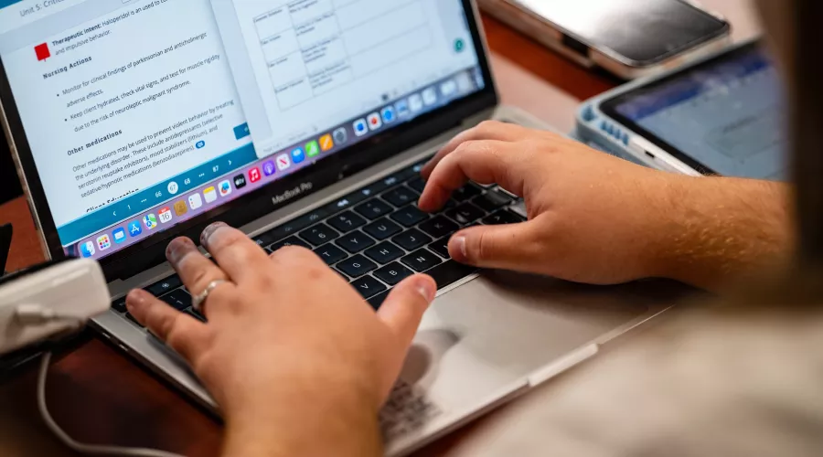 Students in a nursing lecture listening and taking notes.