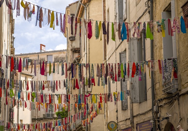 Colorful ribbons strung between old buildings