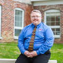 Aaron N. Coleman sitting on outdoor ledge