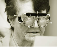 Elderly woman views paper through lenses