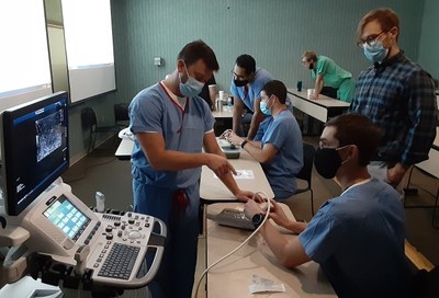 Residents practice ultrasound technique with Dr. Glaenzer.
