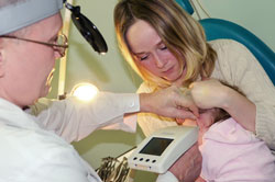 a doctor examines an infant with their guardian