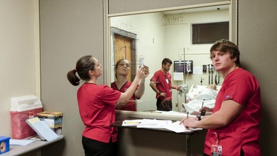 Three students participating in a simulated nursing scenario