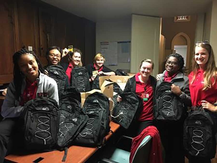 Nursing students providing backpacks and education to homeless men.