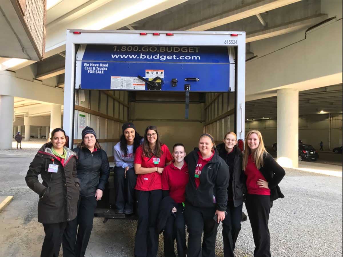 Eight nursing students pictured at box truck preparing for Wayside clothing drive.