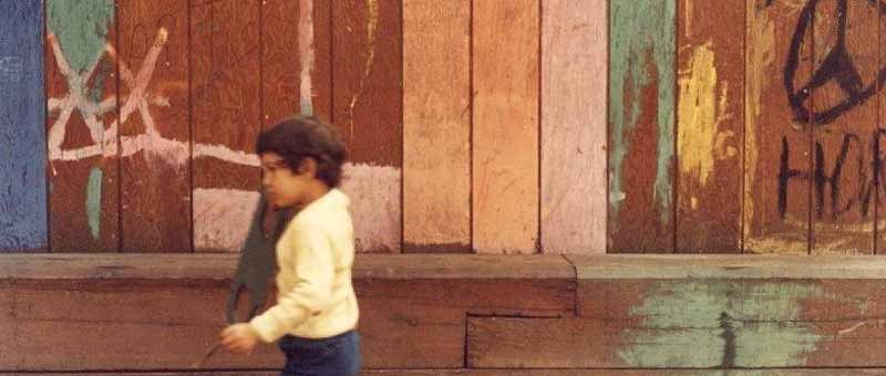 Young boy walking in front of a peace sign