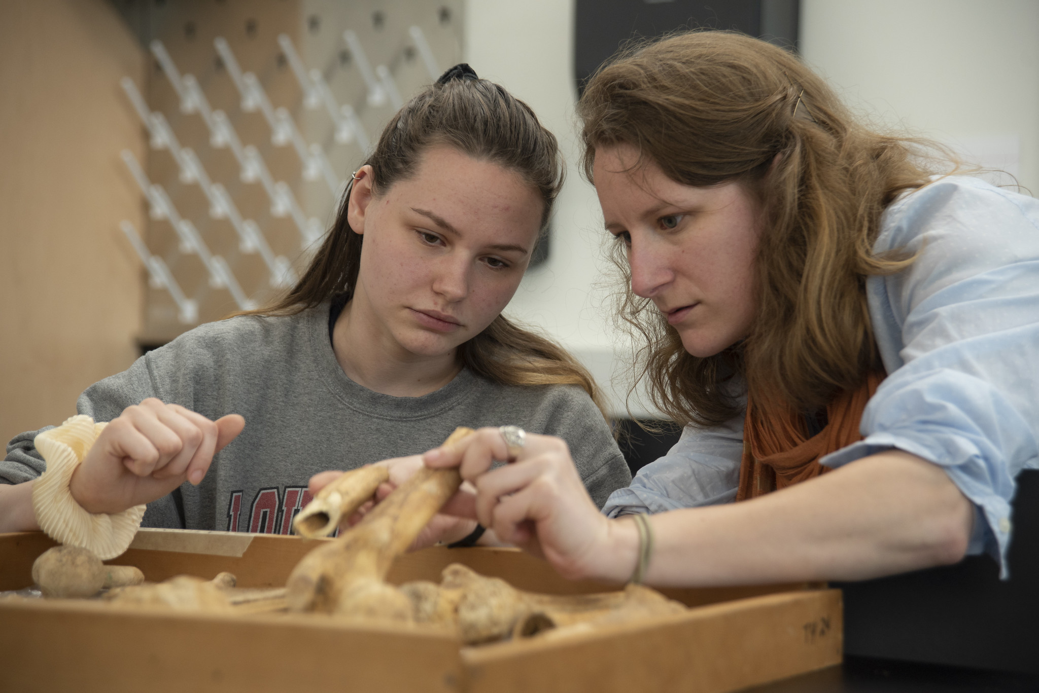 Professor assisting student with review of archeological items