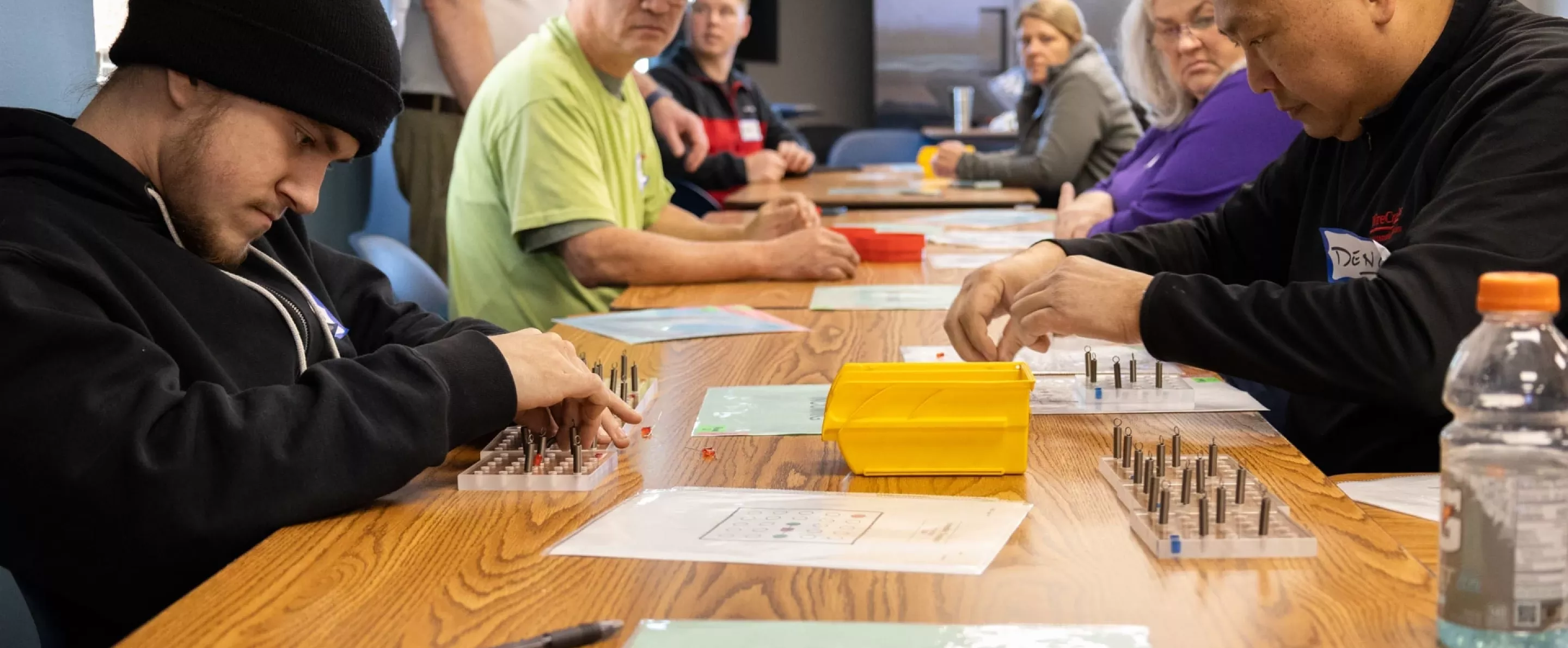 Group of people in a classroom setting participating in hands-on Lean 101 training activities.