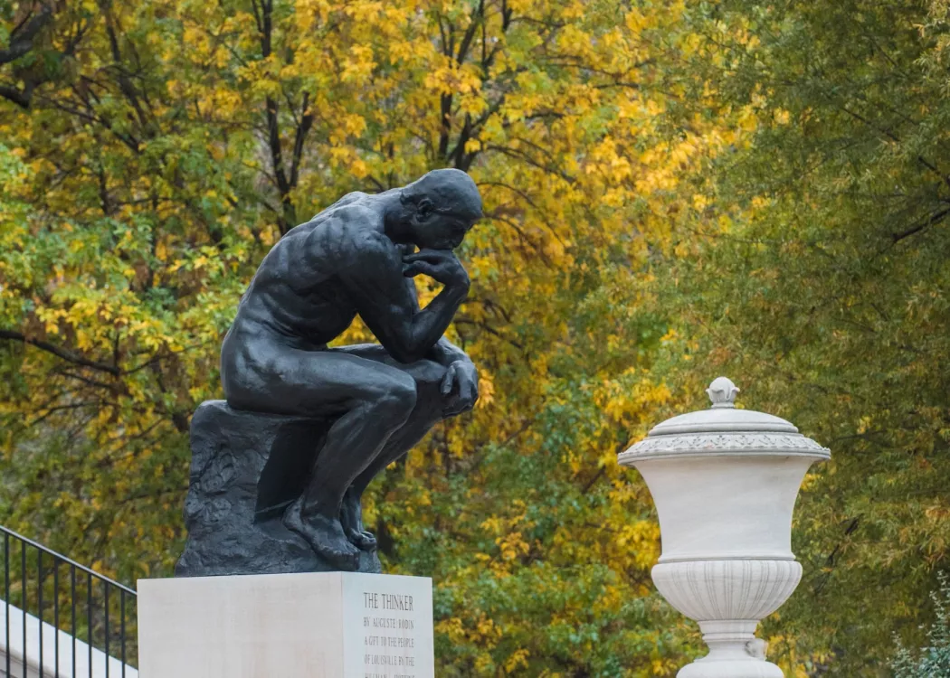 Steps of Grawemeyer Hall and The Thinker against fall trees