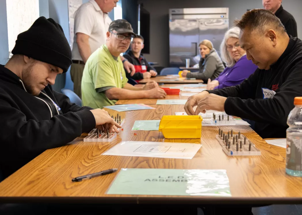 Group of people in a classroom setting participating in hands-on Lean 101 training activities.