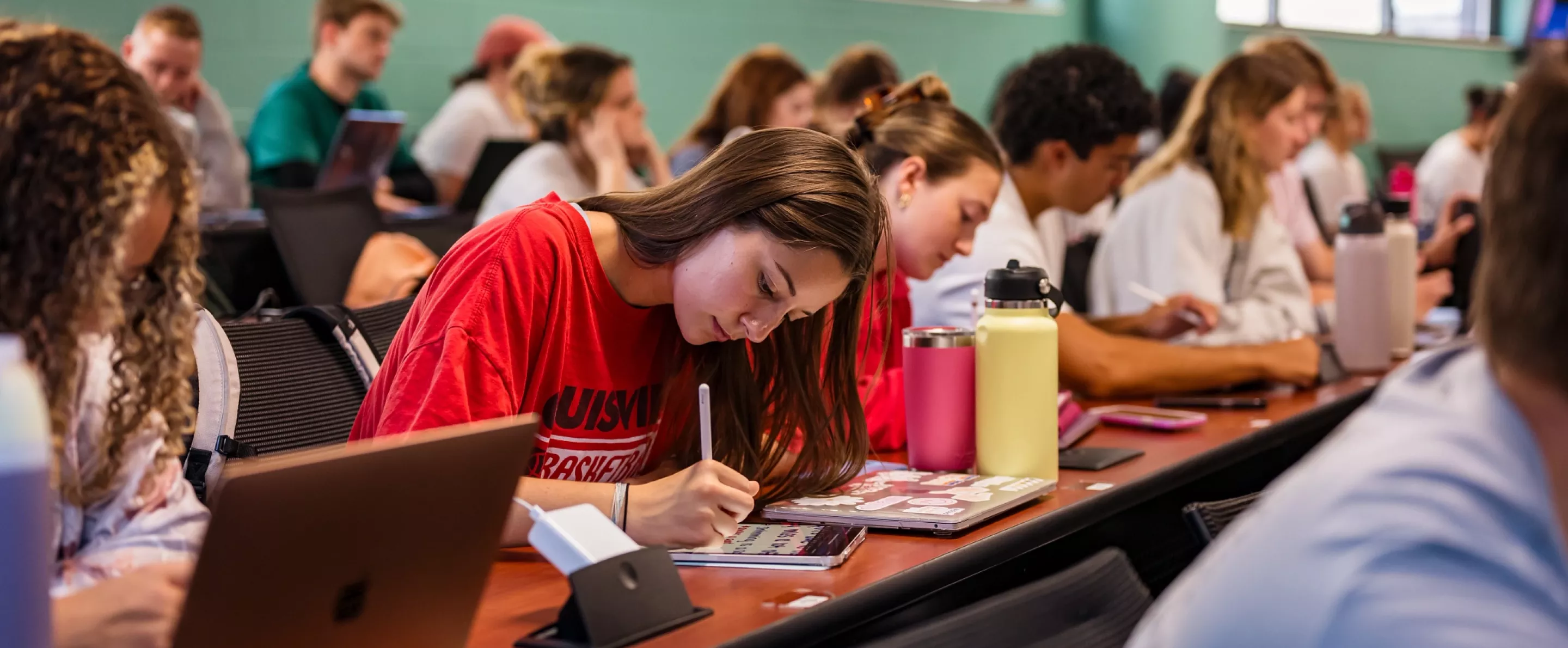 Students in a nursing lecture listening and taking notes.