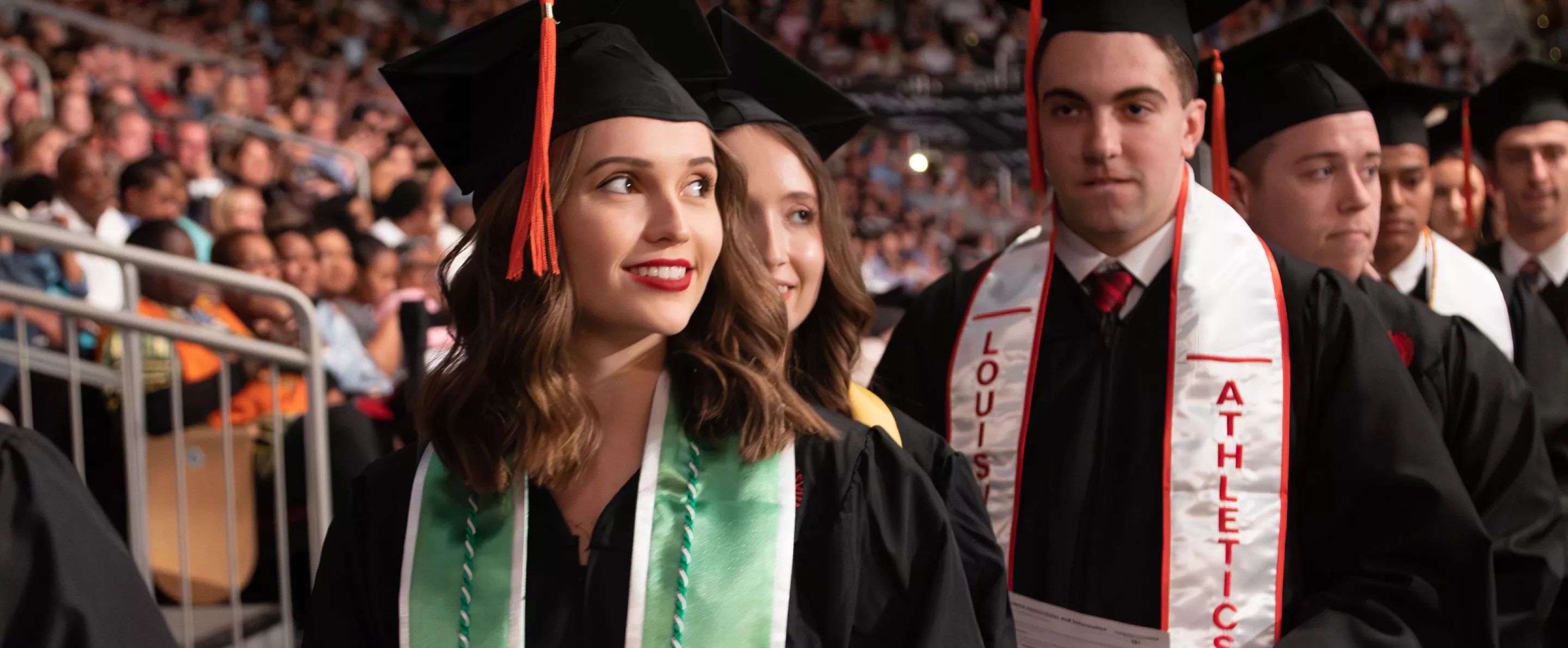 An engineering student smiling in line to walk the stage at commencement.