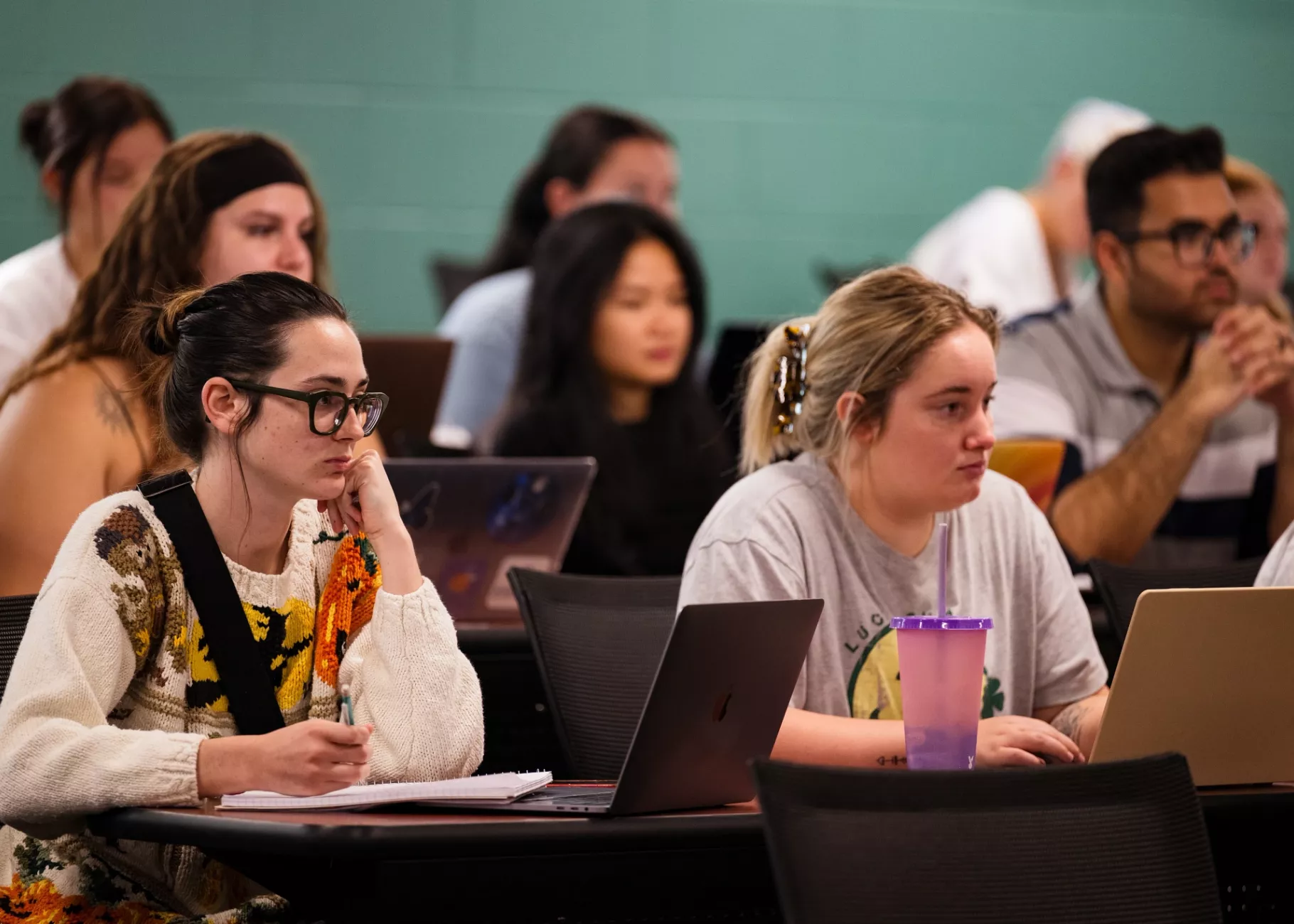 Students in a nursing lecture listening and taking notes.
