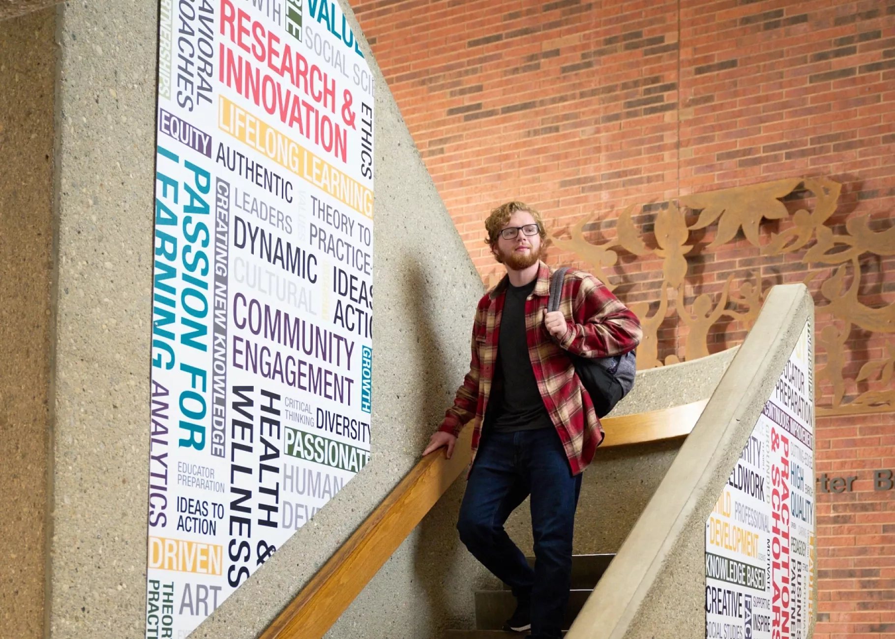 Student walking down the stairs in CEHD.