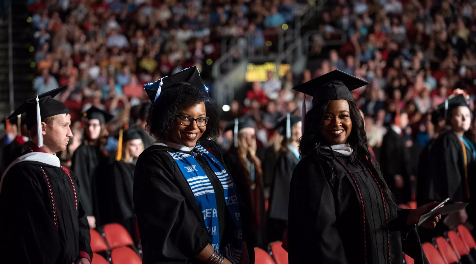 Two graduates smile for a photo