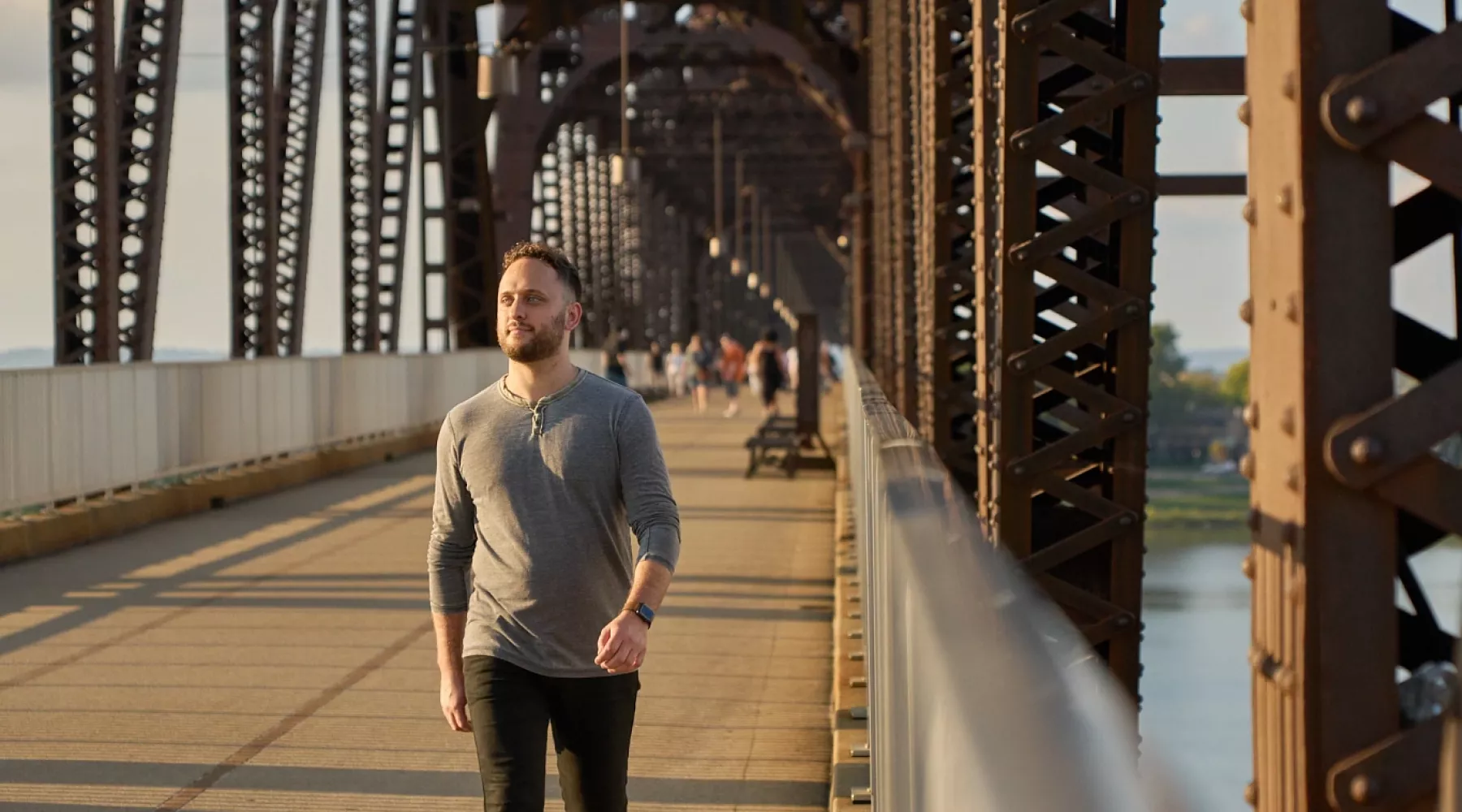 Student walking on the Big Four Bridge at Waterfront Park in downtown Louisville, admiring the view.