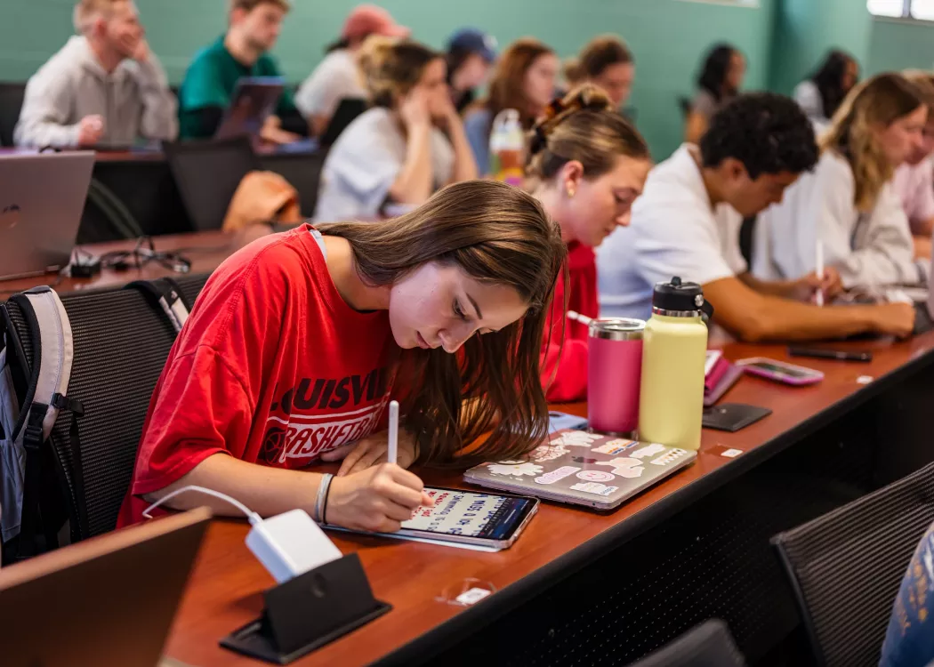 Students in a nursing lecture listening and taking notes.