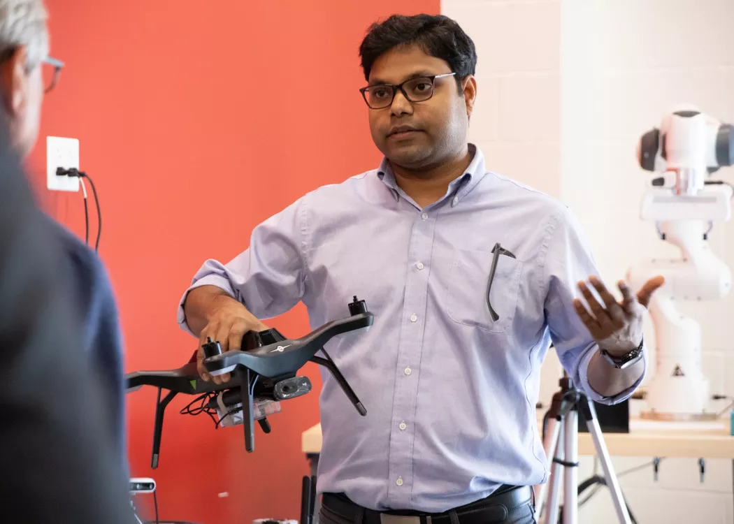 Dr. Sabur Baidya talking while holding a drone.
