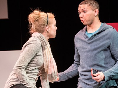 Baltimore production photo female actress and male actor engage together on stage
