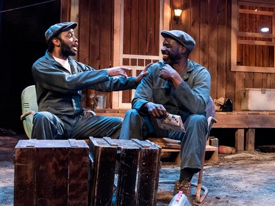 Fences production photo, two African-American males engage in dialogue on stage