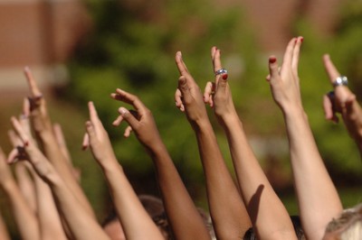 Multiple students hands in the air