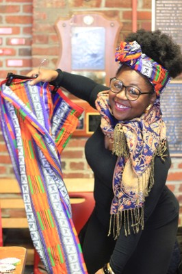 Student holding African cloth IWD