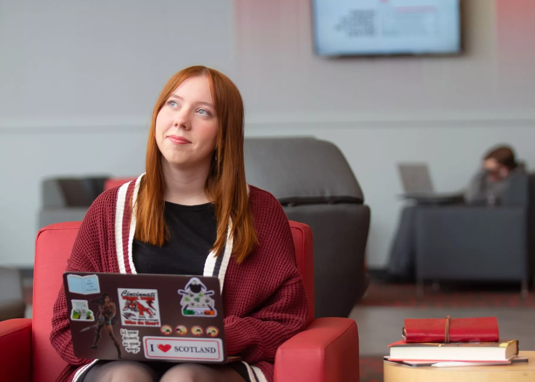 A student pauses in thought while working on a laptop in the Belknap Academic Building