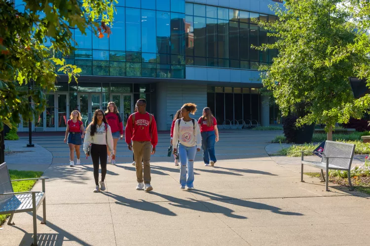 A group of students leaving the Belknap Academic Building on a sunny morning